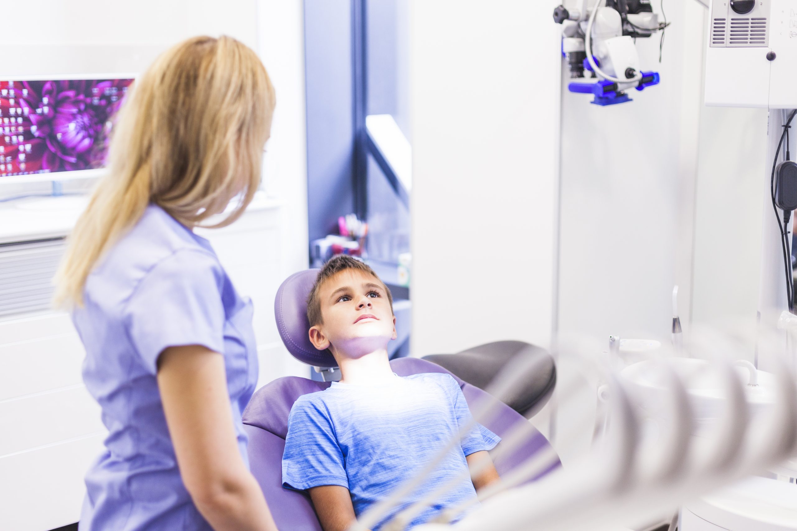 dentist-standing-near-boy-sitting-dental-chair