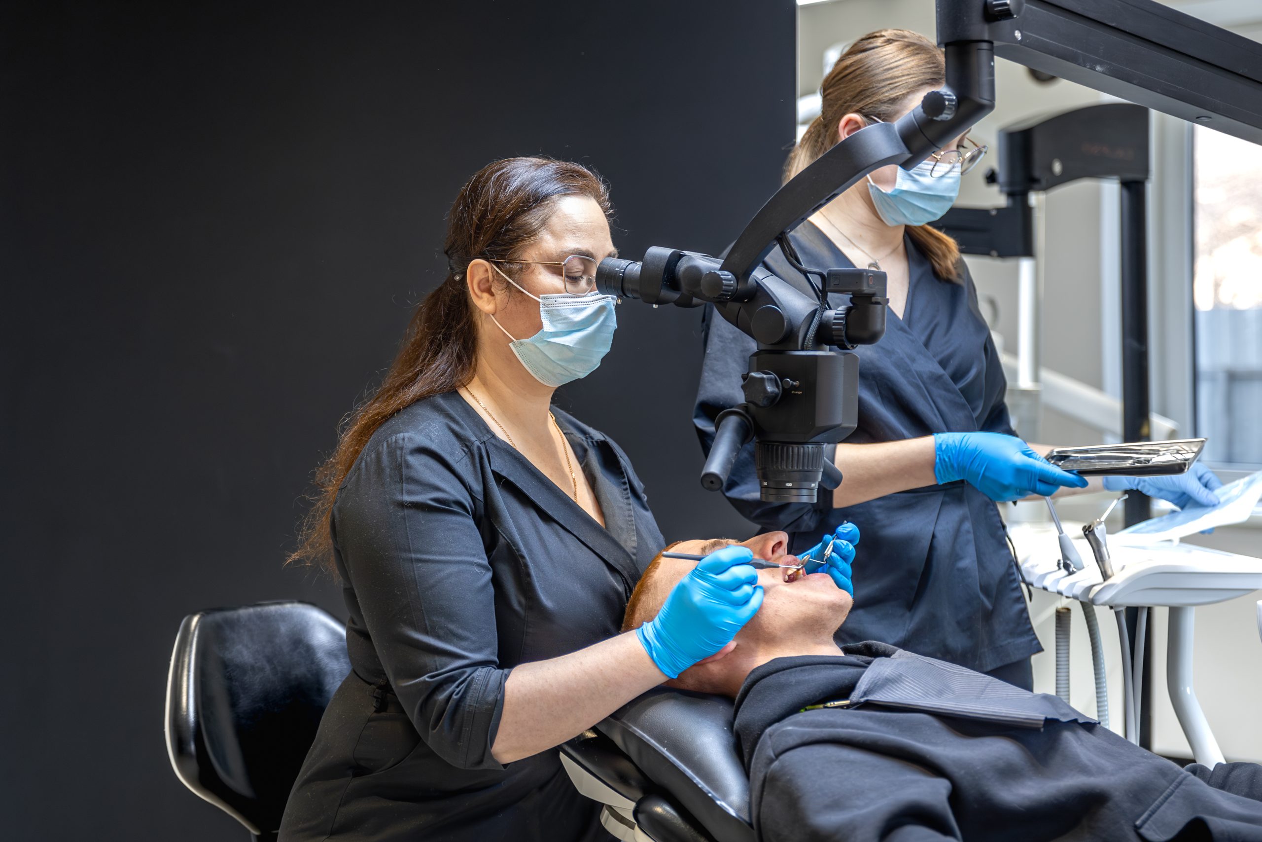 A team of dentists treats a patient's teeth using modern equipment. Dentistry concept. High quality photo. Professional dental treatment in the dentist's office. SSUCv3H4sIAAAAAAAAA41Py26DMBD8lz2DxKMUh1+JejD2QlYBHNnrRhXyv3dNiHqtTzM73pnZHcjCAKNtEc1YlZPuu7KucSqVbfqynlTX9uqisGmhAKsZYajbVnWXj6ZWTfWpKnkFjDqQgWEHWpYY2Gsmt8EgisfNoj8gWmLnSS/CUgGBNceAQdaEGfGeRT342++657kUlPAQxwxS8c/ZVwF6xs38ZP+Uiyyoj7irSPcno1/PbMe3XDHDhydD23x2klPc+sKb47x7JLAzd7Ln8uuMG8nU5yyIj8Vpi/aU47gS85t6/CZ8/v1OKf0CuoecMYQBAAA=